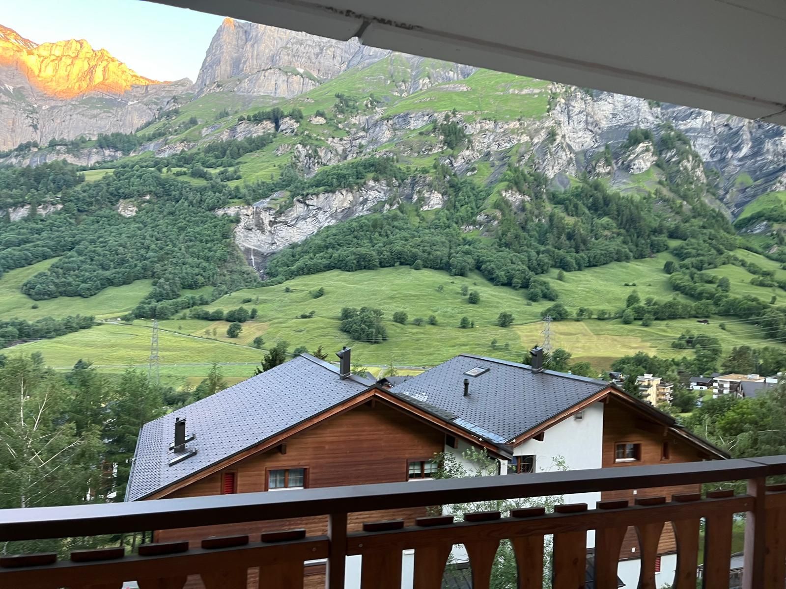 Green summer meadows and a waterfall seen from the balcony