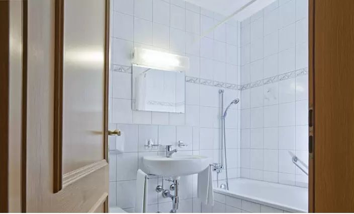 White tiled bathroom with bathtub