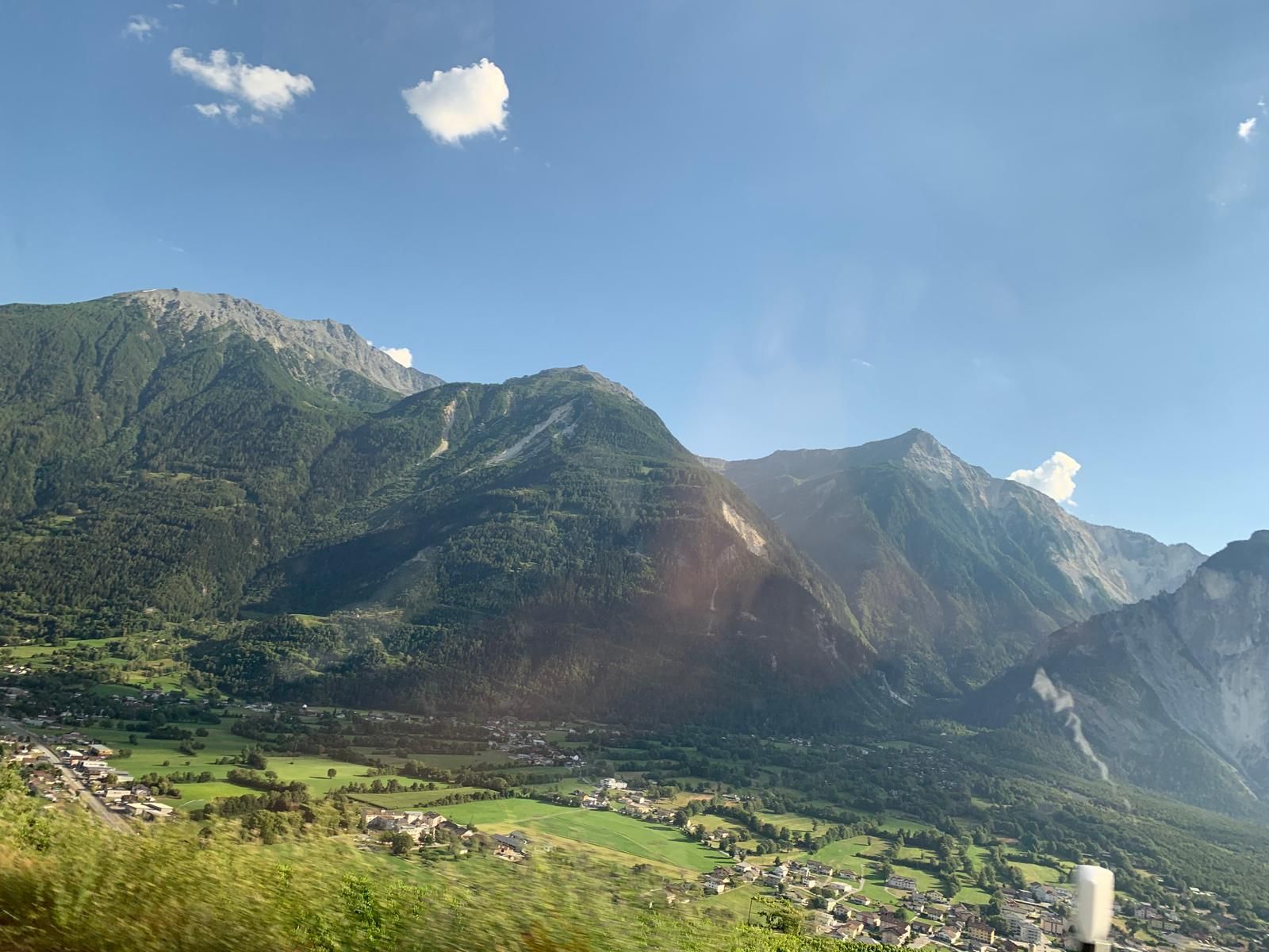 Forested mountains above a green valley village